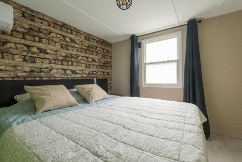 a bedroom with a brick wall and a bed at 49, Efteling - Beekse Bergen - Dog Friendly in Oisterwijk