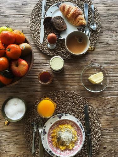 een tafel met borden vol ontbijtproducten en koffie bij Aux Petits Bourgeons in Adainville