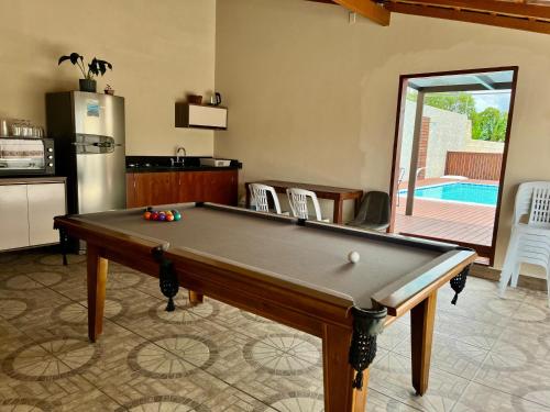 a kitchen with a pool table in a living room at Acomodação Cambirela in Palhoça
