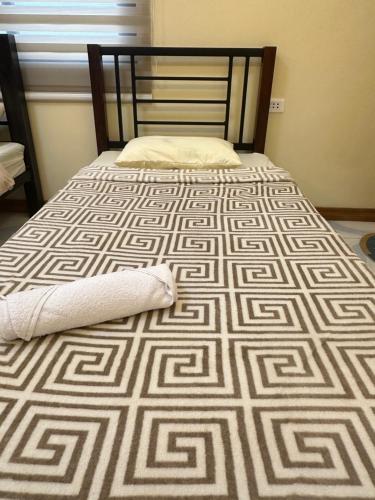 a bed with a blanket and a pillow on it at Rivero Transient House in San Fernando