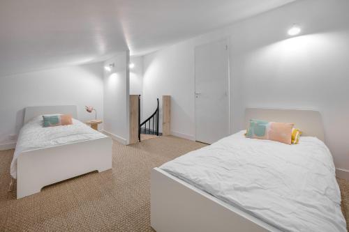 ein weißes Schlafzimmer mit 2 Betten und einer Treppe in der Unterkunft À 400m de la plage, maison renovée pour 6 in Préfailles