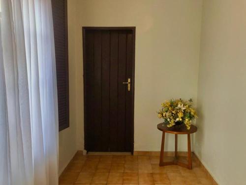 a room with a door and a table with flowers on it at Pousada Jardins in Santarém