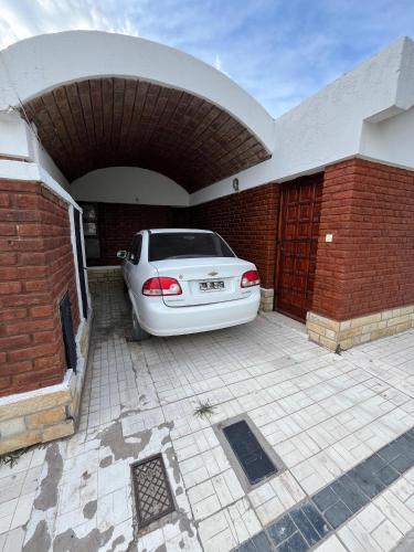 a white car is parked in a garage at CASA "GUILLE" pleno centro, 200mts de peatonal y 300mts de la playa in Las Grutas