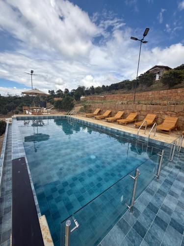a large swimming pool with blue water and chairs at Hotel Cariguá in Barichara