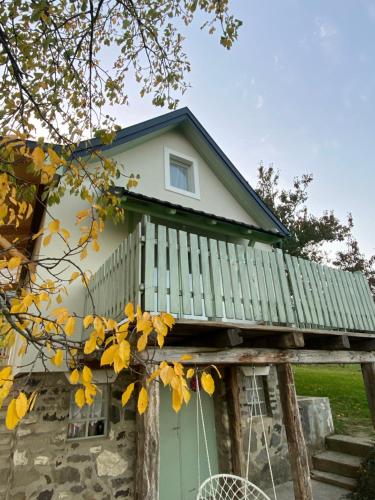 a house with a green door and a porch at Somlói Provence in Doba