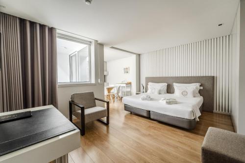 a hotel room with a bed and a chair at Sé INN Studios by House and People in Braga