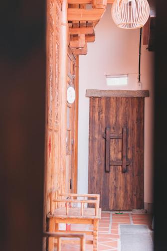 a room with a wooden door and a wooden chair at 新龍頭古厝本館 Shin Long Tou B&B in Jinning