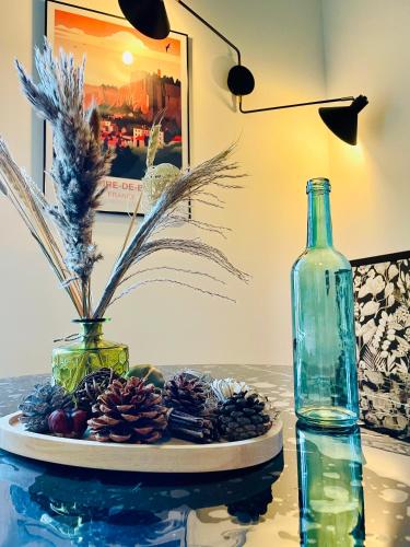 - une table avec une plaque en pin et une bouteille dans l'établissement 101 - Appartement élégant art déco près du centre ville, à Belfort