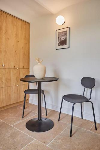 une table, deux chaises et un vase sur une table dans l'établissement TERRE UGO - Studio campagne Aixoise #6, à Aix-en-Provence