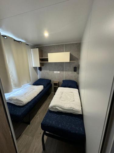 a small room with two beds and a bench at Neu 6Pers Chalet De Oase Renesse Nordsee in Renesse