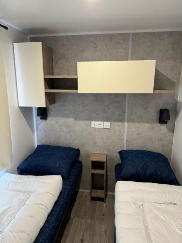 a small room with two beds and a shelf at Neu 6Pers Chalet De Oase Renesse Nordsee in Renesse