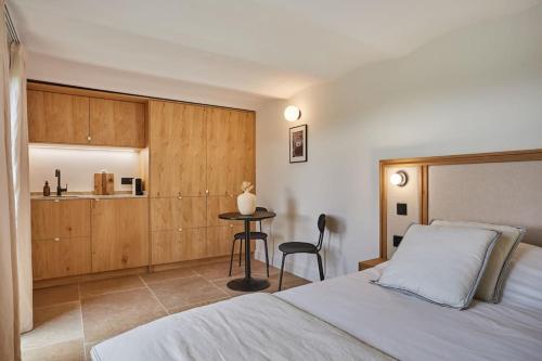 une chambre avec un lit et une table et une cuisine dans l'établissement TERRE UGO - Studio campagne Aixoise #6, à Aix-en-Provence