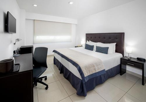 a bedroom with a bed and a desk and a television at Hotel México Plaza Celaya in Celaya