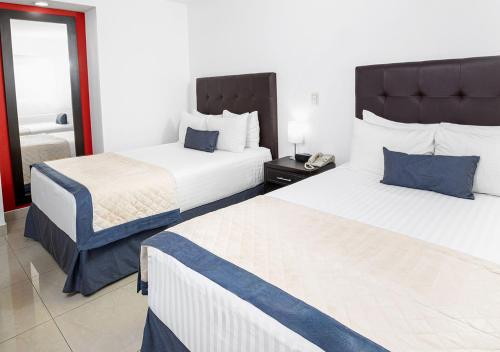 a hotel room with two beds and a phone at Hotel México Plaza Celaya in Celaya