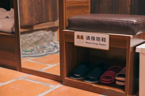 a pair of shoes in a wooden box with a sign at 新龍頭古厝本館 Shin Long Tou B&B in Jinning