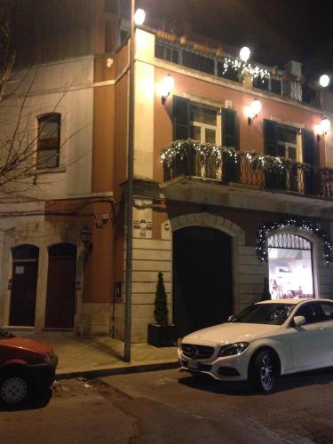 a white car parked in front of a building at night at Dolce Farinella in Putignano