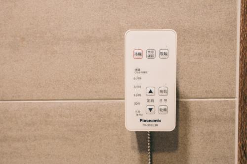 a white remote control attached to a wall at 新龍頭古厝本館 Shin Long Tou B&B in Jinning