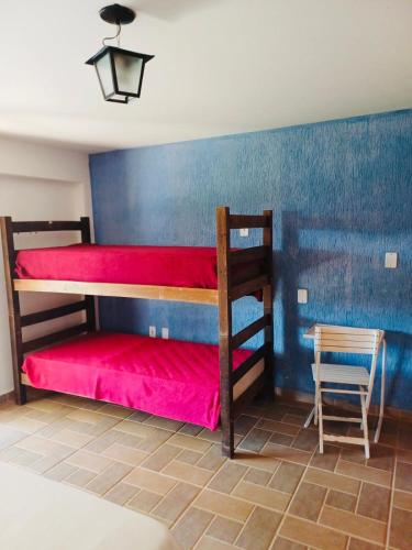 a bedroom with two bunk beds and a chair at Suite Na Chácara da Casa Azul in Socorro