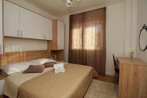 a bedroom with a bed and a desk and a desk at Apartments Obitelj Vuletić in Makarska