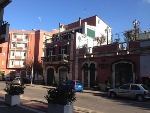 a city street with cars parked in front of a building at Dolce Farinella in Putignano