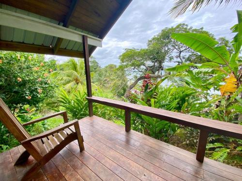 a wooden porch with a bench on a deck at Bird Island Bungalows in Bocas del Toro