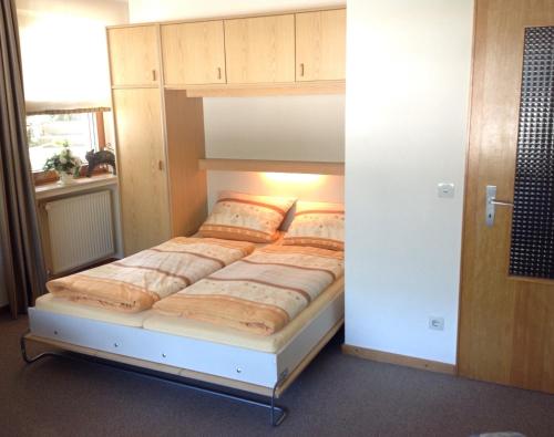 a bedroom with a bed in a room with a cabinet at Haus Mittelberg in Olsberg