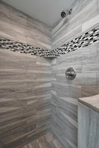 a bathroom with a shower with wooden tiles at The Perch at Kimberling Crossing in Kimberling City