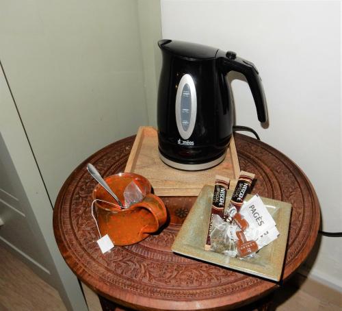 a table with a coffee pot and a heart on a table at Le logis d'Hestia in Billom