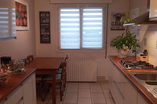 une cuisine avec une table, un évier et une fenêtre dans l'établissement Superbe appartement Clermont-Ferrand, à Clermont-Ferrand