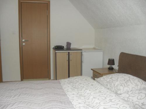 a bedroom with a bed and a table and a door at Golubović Apartments in Žabljak