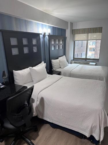 a hotel room with two beds and a desk at Fairfield Inn & Suites by Marriott New York Manhattan/Chelsea in New York