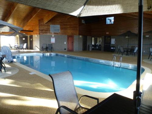 a large swimming pool with chairs in a building at AmericInn by Wyndham Mitchell in Mitchell