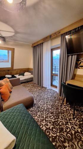 Una habitación de hotel con dos camas y un televisor de pantalla plana. en Willa u Kośle Zakopane, en Zakopane