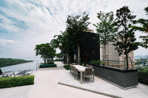 a patio with a table and chairs and a view of the water at Urban Suites Seaview 3Bedrooms 2Carparks 8pax in Jelutong