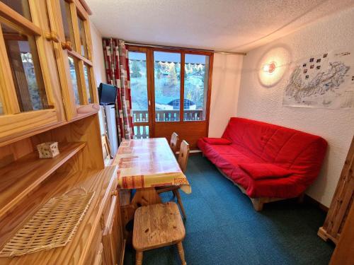 un salon avec un canapé rouge et une table dans l'établissement Studio cosy 4 pers, sud, au cœur d'une station proche pistes et commerces, Modane - FR-1-265-227, à Valfréjus