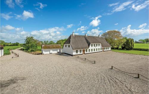 a large white building with a roof on a gravel driveway at Six-Bedroom Holiday Home In Haderslev in Haderslev