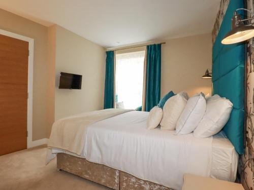 a bedroom with a large bed with white pillows at Kerensa in St Austell