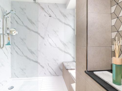 a bathroom with white marble walls and a shower at Kerensa in St Austell