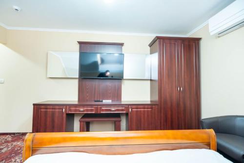 a hotel room with a tv and a bed at Dinasty Hotel in Sîntana