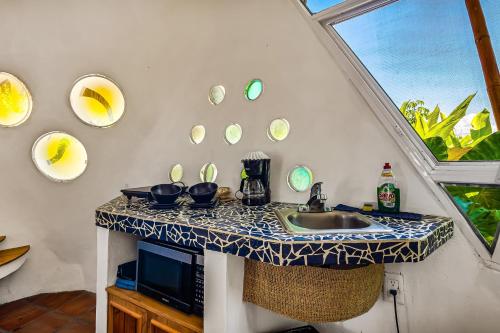 a kitchen with a sink and a counter with plates on the wall at Villas Bambu in Barra de Navidad