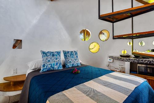 a bedroom with a bed with blue and white pillows at Villas Bambu in Barra de Navidad