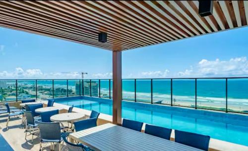 a swimming pool with a view of the ocean at Studio aconchegante! in Salvador
