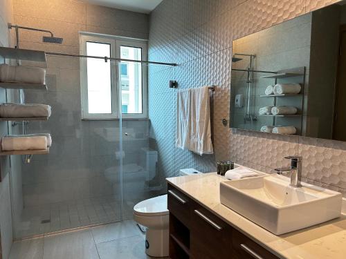 a bathroom with a sink and a shower and a toilet at AmazINN Places Playa Escondida in María Chiquita