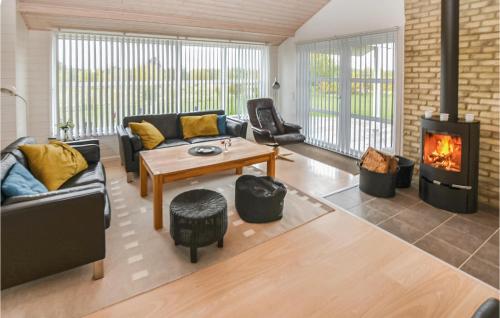 a living room with a couch and a fireplace at Holiday Home Pilemose in Skovby