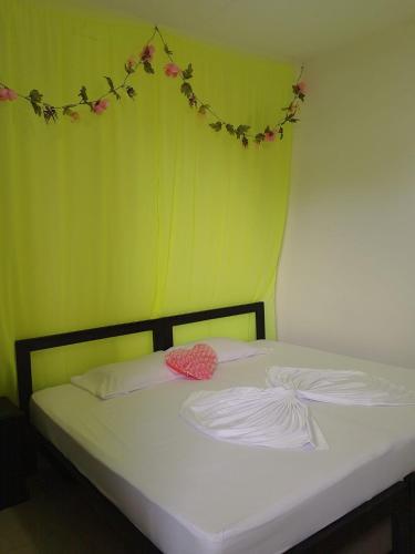a bedroom with a bed with a green wall at Hospedaje Casa Cultural Saberes in Neiva