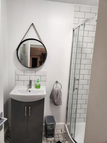 a bathroom with a sink and a mirror at Beautiful stylish house near town centre in Rugby