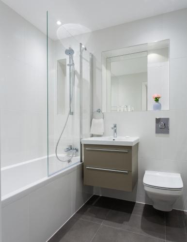 a bathroom with a toilet and a sink and a shower at Queens Park by Viridian Apartments in London