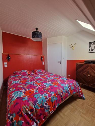 1 dormitorio con 1 cama grande y edredón colorido en Opal'In proche de la plage et des restaurants, en Gravelines