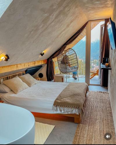 a bedroom with a bed and a large window at Shard Boutique Hotel-adult only in Braşov