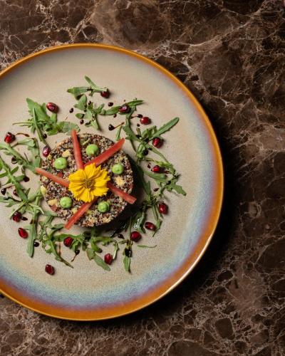 a plate with a salad with a yellow flower on it at Pullman Lima Miraflores in Lima